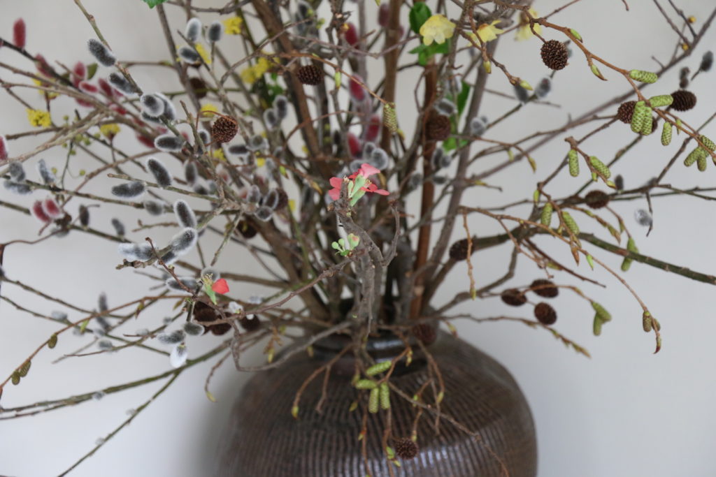 美しい花瓶に生けられた様々な植物の枝